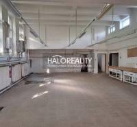 A space with tiled flooring, large windows, and work desks in commercial premises.