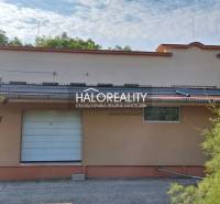 Commercial premises in Čakajovce with garage doors, set in greenery.