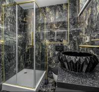 Luxurious bathroom with black marble and gold accessories in a family house.
