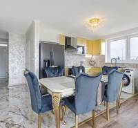 Dining room in a family house with a marble floor, blue chairs, and a gold table.