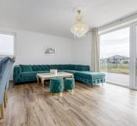 Living room in a family house with a turquoise sofa and a floor with a wooden decor.