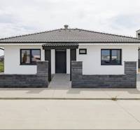 A family house in Hrubá Borša with a gray roof, modern facade, and front garden.