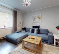 Living room in a family house with a corner sofa and a floor with a wooden decor.
