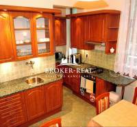 A kitchen with wooden cabinets and a marble countertop, Hotels and guesthouses.