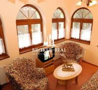 Living room with arched windows, patterned furniture, and a television. Hotels and guesthouses.