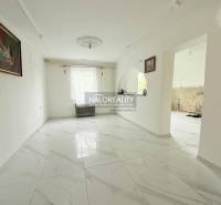 A living room in a family house with white walls and marble flooring.