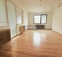 A room in a family house with a wooden decor floor and radiators.
