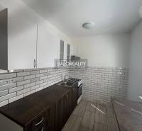 The kitchen in the 3-room apartment has ceramic tiles and a floor with a wooden decor.