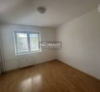 A room in a 3-room apartment with white walls and a floor with a wood decor.