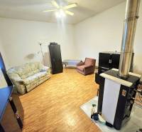 Living room in a family house with a wooden decor floor, sofa, and fireplace.