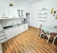 Kitchen in a family house with white cabinets and wood-patterned flooring.