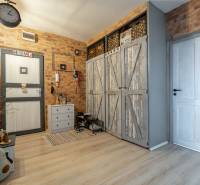 Entrance hall in a 3-room apartment with brick walls and a wooden decor floor.