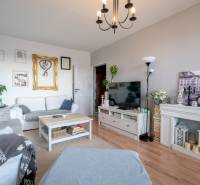 Living room in a 3-room apartment with white furniture and a floor with a wood decor.