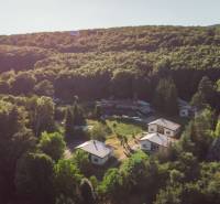 Aerial view of cottages surrounded by forest in Prašice.