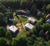 An aerial view of cottages in Prašice surrounded by dense forest and greenery.