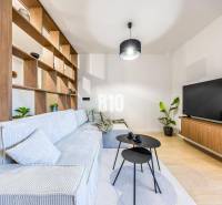 Living room in a 3-room apartment with a sofa, television, and wooden decor.