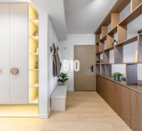 Entrance hall with wooden decor, white cabinets, and a shelf in a 3-room apartment.