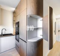 A kitchen in a 3-room apartment with a wooden decor floor and built-in appliances.