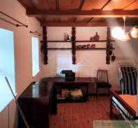 Interior of a cabin with a wood-patterned floor, a desk, and a chair.