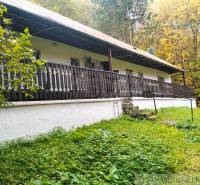 A cottage surrounded by greenery in Chocholná-Velčice, with wooden veranda railings.
