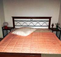 Simple bed in a cabin with a wooden headboard and lamps on the nightstands.