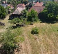 Commercial land in Čaradice, with greenery and buildings in the background.