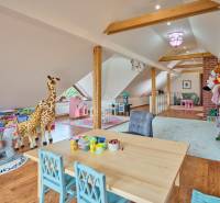 Children's playroom in a villa with a wooden decor floor, lots of toys, and a table for creativity.