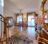 Interior of a villa with elegant furniture, a chandelier, and a wooden decor floor.