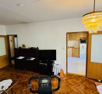 Living room with wood-patterned flooring, view of the kitchen in a 3-room apartment.