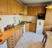 A kitchen in a 3-room apartment with a wooden decor floor and a corner unit.