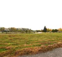 Commercial plots on Nebojsa Street in Galanta with grassy surfaces and surrounding trees.
