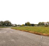 Commercial land in Galanta on Nebojsa Street, with an asphalt road and green surroundings.