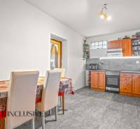 A kitchen in a family house with a dining table and a wooden kitchen unit.