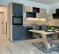 The kitchen of a 3-room apartment with a dining table, floor with wooden decor.