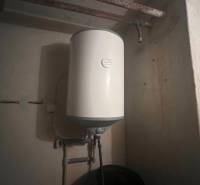 A boiler in a family house with a simple piping system and a dark environment.