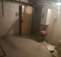 Basement with stairs in a family house, simple walls and a boiler.
