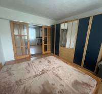 Bedroom in a family house with a bed, wardrobe, and sliding doors with glazing.