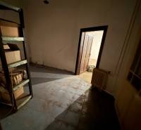 A dark room with a shelf, a door, and a radiator in a family house.