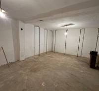 Empty room in a family house with a concrete floor and white walls.