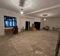 A spacious interior in a family house with a concrete floor, a window, and a bicycle.