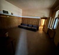 A dark room with a sofa and wooden paneling in a family house.