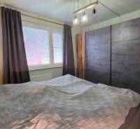 A bedroom in a 3-room apartment with a large wardrobe and a wooden decor floor.