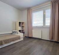 Children's room in a 3-room apartment with a wooden decor floor, bed, and wardrobe.