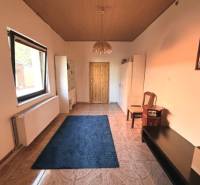 Room with tiles, carpet, furniture, and a large window in a family house.