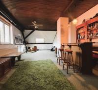 Family house with a wooden decor floor, a bar, and a green carpet.