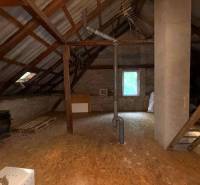 Attic in a family house with wooden beams and a chimney, floor with wooden decor.