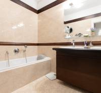 A bathroom with a bathtub and two sinks in a 3-room apartment, beige tiles.