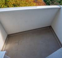 A balcony with tiles and a view of autumn nature in a 3-room apartment.