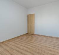 Empty room with white walls and a floor with a wood decor, 3-room apartment.