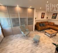 Living room with a sofa, an armchair, and a wooden decor floor in a 3-room apartment.